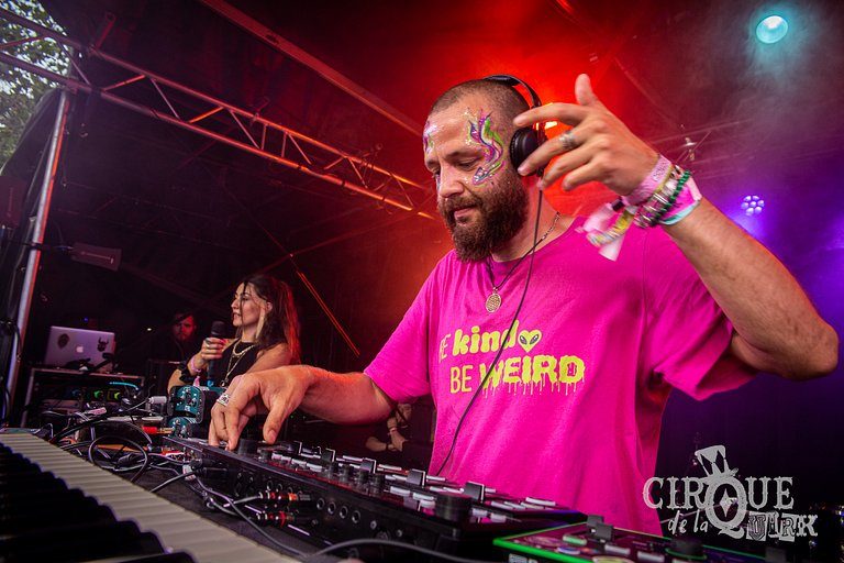 Beat Cleaver DJing in a pink Be Kind Be Weird tee